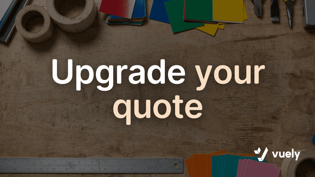 Upgrade your quote. A wooden sign shop workbench cleared in the middle with vinyl swatches and measuring tools along the edges.